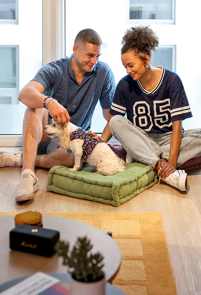 young couple playing with a small dog